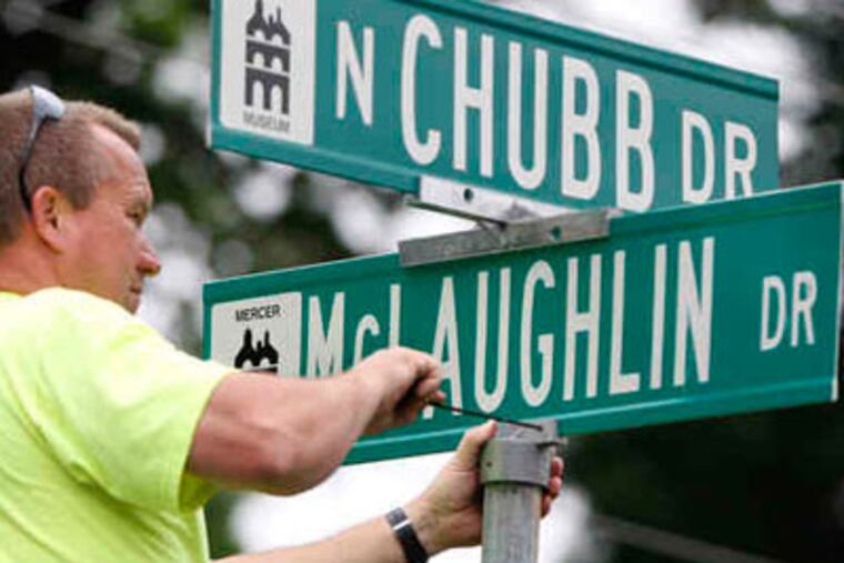 New street signs, at North Chubb and McLaughlin Drives, are put up by Doylestown employee Kevin Michener. Those roads, and nine more in the Maplewood area, are named for residents killed in World War II. (ELIZABETH ROBERTSON / Staff Photographer)