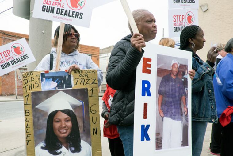 Cynthia Davis, of the group Mothers in Charge, carries a protest sign and a picture of her granddaughter Jasmine, who was killed with a handgun, during a rally Saturday, April 25, 2015, in South Philly. (ED HILLE/Staff Photographer)