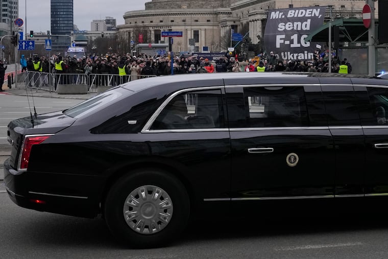 Protestors, rear, hold a sign asking U.S. President Joe Biden to send fighter jets to the Ukraine as he leaves his hotel for the Polish Presidential Palace for a meeting with the B9 leaders in Warsaw, Poland, on Wednesday.