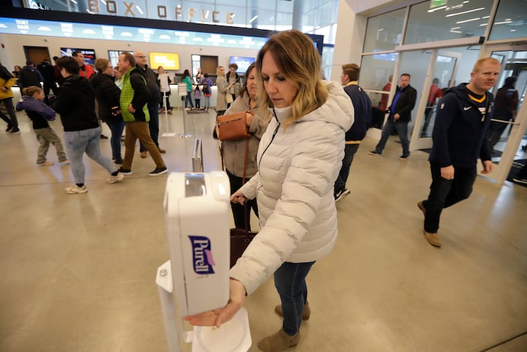 A fan uses a sanitizing station at the Vivint Smart Home Arena before a game between the Toronto Raptors and the Utah Jazz in Salt Lake City.