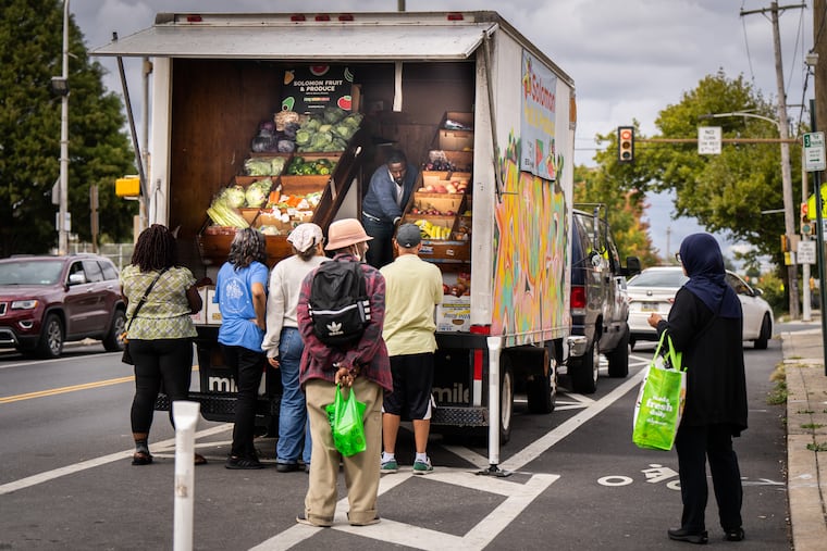 Solomon Tsegay works at his business, Solomon Fruit and Produce, at 48th and Spruce Streets.
