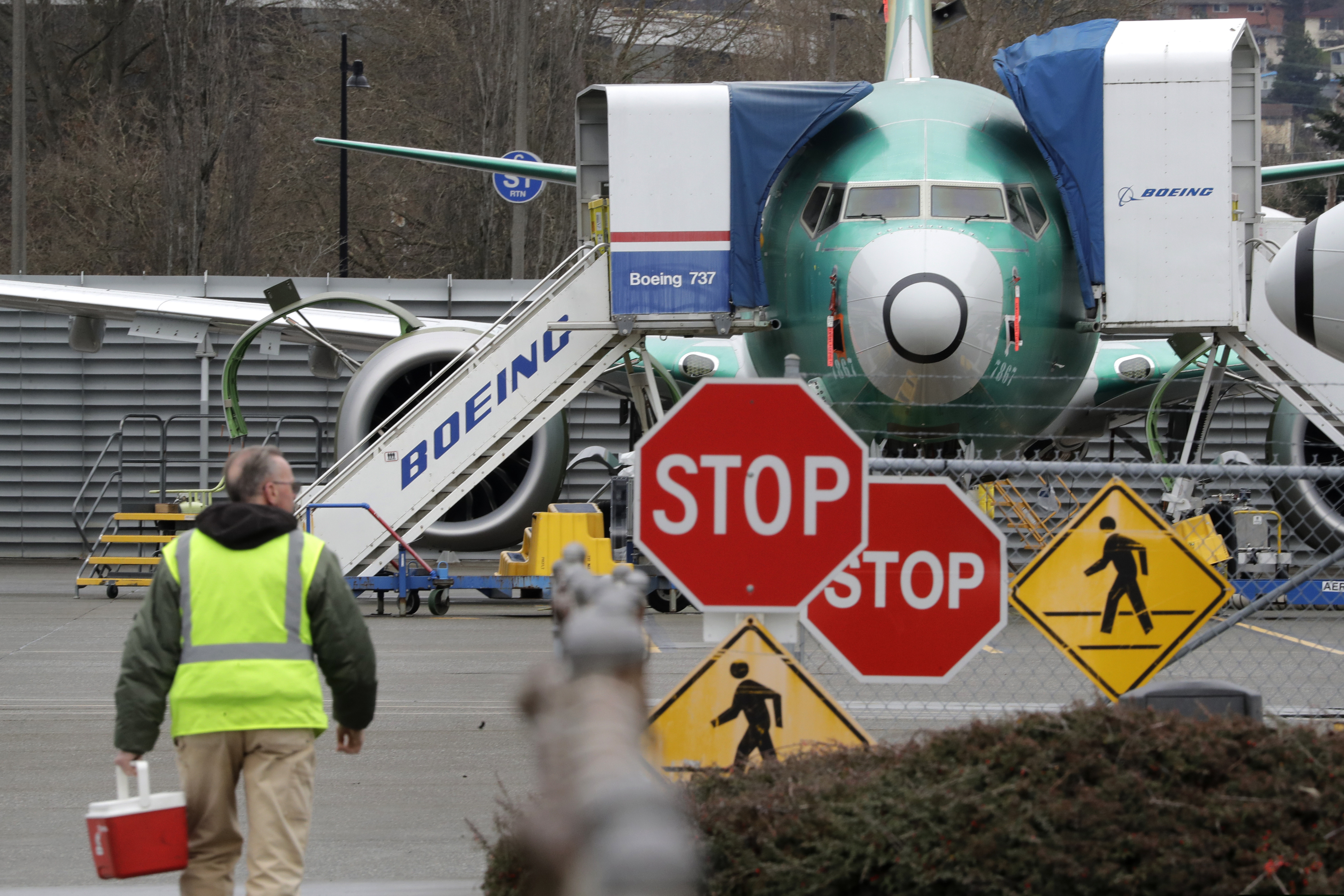A Boeing worker walks in view of a 737 MAX jet in Renton, Wash.
