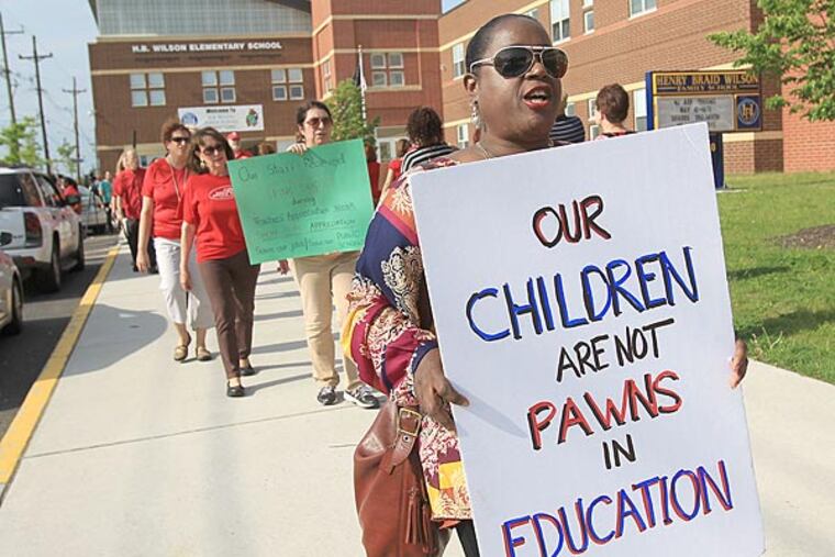 File photo: Debbie Flores, a kindergarten teacher at Sharp Elementary, and other teachers carry signs outside of H.B. Wilson Elementary School over possible job layoffs. ( CHARLES FOX / Staff Photographer /May 12, 2014)