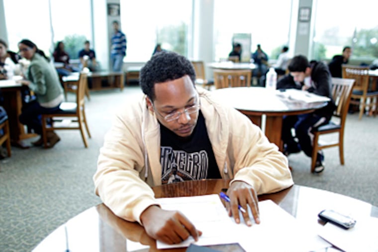N.J. schools will look to better retain new students like Jamir Morrison, 34, who fills out admissions paperwork at Burlington County College's site in Mount Laurel. (David Swanson / Staff Photographer)