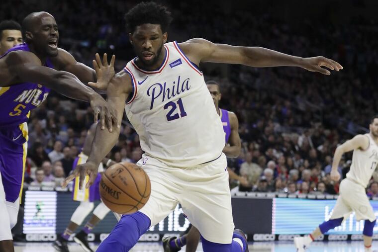 Sixers center Joel Embiid after the loose basketball against New Orleans Pelicans center Emeka Okafor during the first-quarter on Friday, February 9, 2018 in Philadelphia.