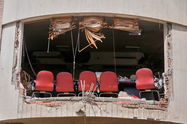 A row of chairs is seen through a hole left by U.S.-Israeli airstrikes Friday at Shahid Beheshti University in Tehran, Iran, Saturday, April 4, 2026.