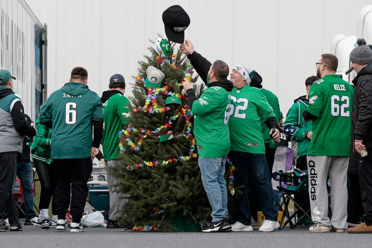 Mark “Bubba” Averill (#62 wearing knit hat) puts the finishing touches on the Christmas tree the group brought with them to the N.Y. Giants at Philadelphia Eagles NFL game at Lincoln Financial Field. Bubba and friends are members of the Shooting Stars Mummers band in South Philadelphia. He said they brought their Polynesian-themed tree right from their Second Street clubhouse.