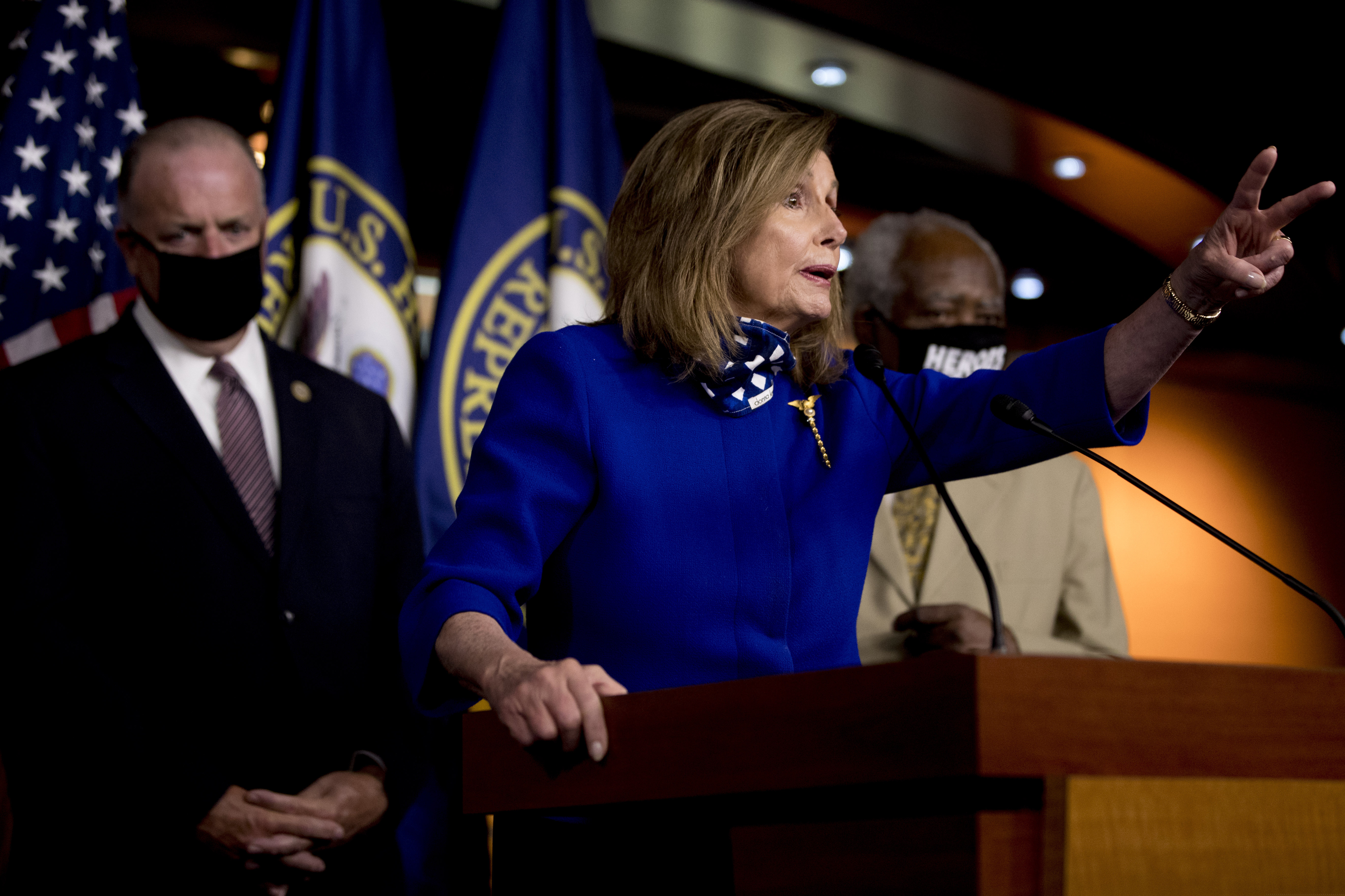 House Speaker Nancy Pelosi of Calif., accompanied by Rep. Dan Kildee, D-Mich., left, and Rep. Danny Davis, D-Ill., right, speaking at a news conference on Capitol Hill in Washington on Friday.