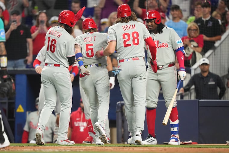 Bryson Stott (center) celebrates with teammates after hitting a three-run home run in the first inning.