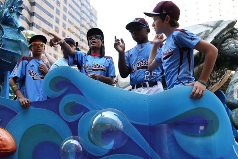 Teammates from the Taney Dragons ride a float during a parade in their honor in Philadelphia.
