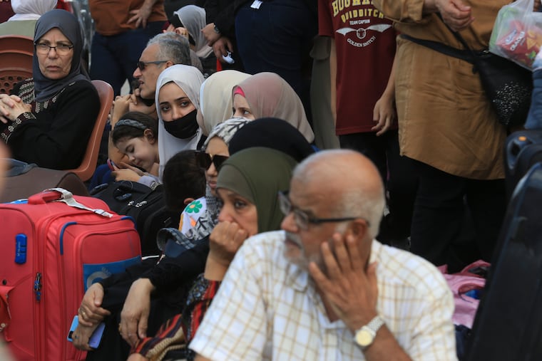 Palestinians wait at the Rafah border crossing between the Gaza Strip and Egypt Gaza Strip on Saturday, Oct. 14, 2023. Israel carried out some limited ground operations ahead of an expected broader land offensive against Gaza's militant Hamas rulers following their attack into southern Israel a week ago. (AP Photo/Hatem Ali)