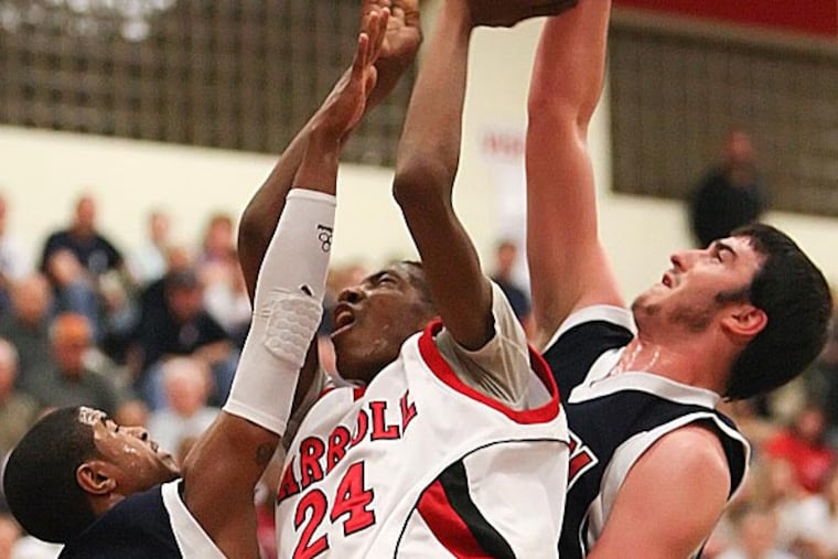 Carroll's Derrick Jones shoots between Octara's Charles Cooper (22) an Anthony DiNorscia during the 2nd quarter of the AAAA Championship Second round in Coatsville, Tuesday, March 13, 2012. ( Steven M. Falk / Staff Photographer )