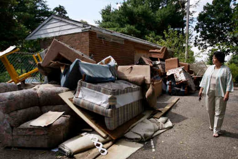 An accumulation of trash at the swimming pool of Arborwood Condominiums catches the eye of Deborah Pysz, a condo owner. Property managers say fewer than a quarter of the owners pay the condo fee.