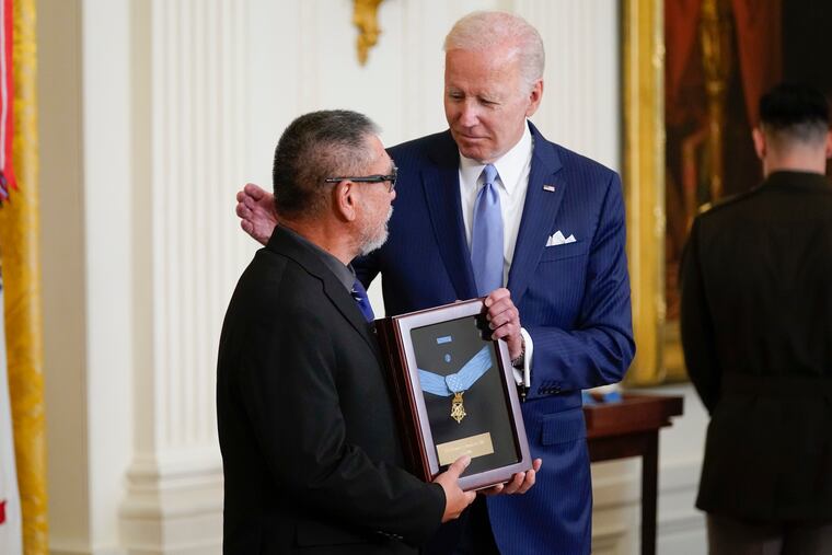 President Joe Biden presents the Medal of Honor to Staff Sgt. Edward Kaneshiro for his actions on Dec. 1, 1966, during the Vietnam War, as his son John Kaneshiro (left) accepts the posthumous recognition during a ceremony in the East Room of the White House.