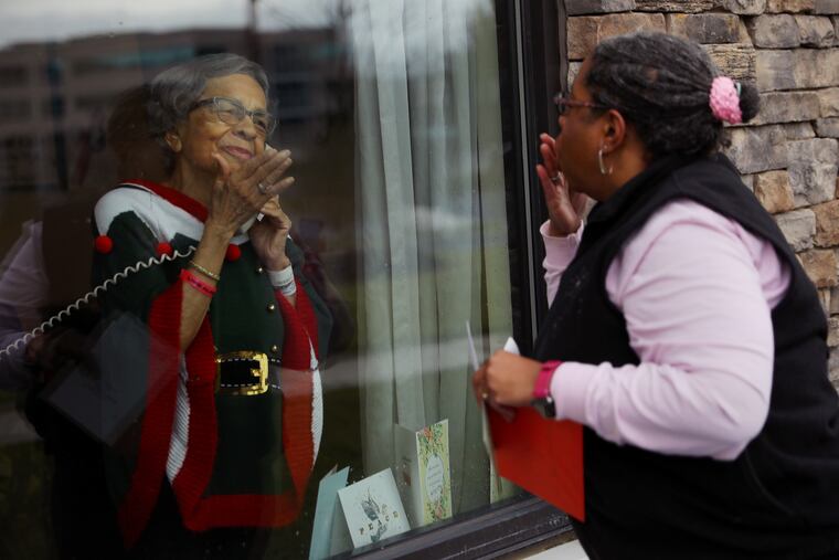Kimberley Burrage (right) of Downingtown blows a kiss to her mother, Annabelle W. Jackson, who is recovering from a procedure at PowerBack Rehabilitation in Exton, Pa., on Christmas, Friday, Dec. 25, 2020. Due to the coronavirus pandemic, Burrage — who recently recovered from COVID-19 but lost her daughter to the disease — could not spend Christmas with her mother, but was able to visit from outside her window.