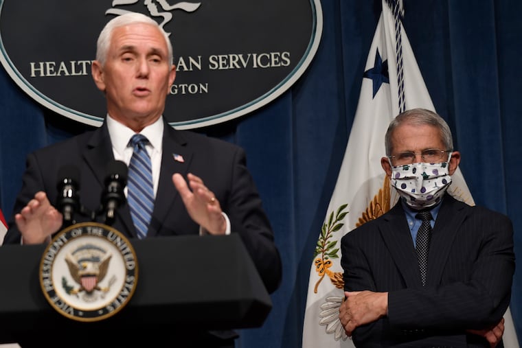 Dr. Anthony Fauci, right, director of the National Institute of Allergy and Infectious Diseases, listens as Vice President Mike Pence speaks during a news conference with the Coronavirus task force at the Department of Health and Human Services in Washington on Friday.