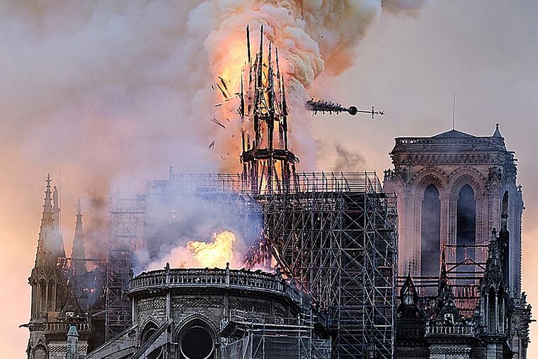 Flames and smoke rise as the spire on Notre Dame Cathedral, added to the structure in the 19th century, collapses in Paris on Monday.