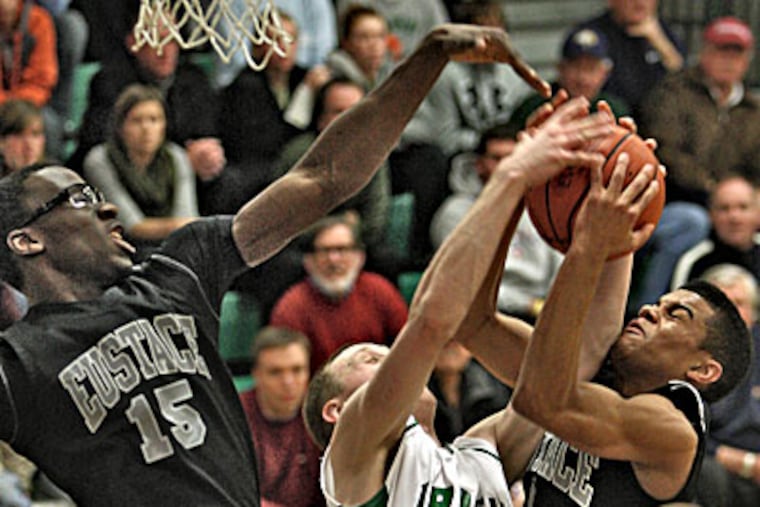 Bishop Eustace's Carson Puriefoy (right) pulls down an offensive rebound with help from teammate Sho Dasilva (left) as Camden Catholic's Kyle Green contests. (David M. Warren/Staff Photographer)