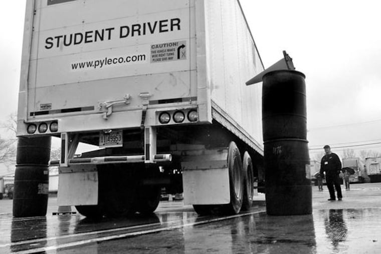 Instructor George Herhei (right) watches as trainee John Uhrinek backs his rig between barrels. "There's more to driving a truck than driving a truck," Herhei told his students.