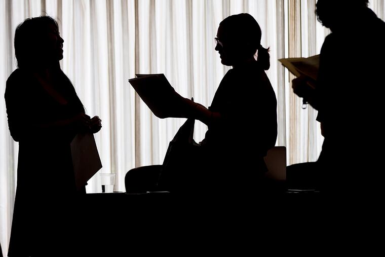 A recruiter, left, with New Western Acquisitions, meets with employment seekers during a job fair in Philadelphia. (AP Photo/Matt Rourke, File)