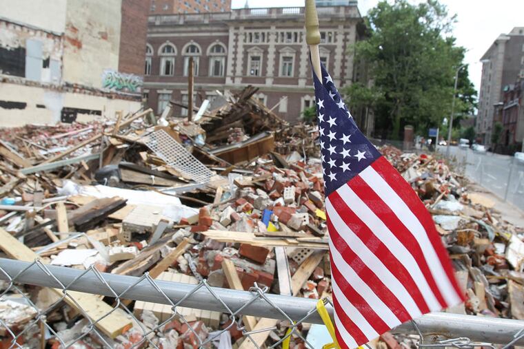 The site of the building collapse at 22nd and Market streets in Philadelphia is shown on June 13, 2013. Everything has now been leveled and is fenced off. Flags, flowers and other memorial items have been placed on or near the fence.
