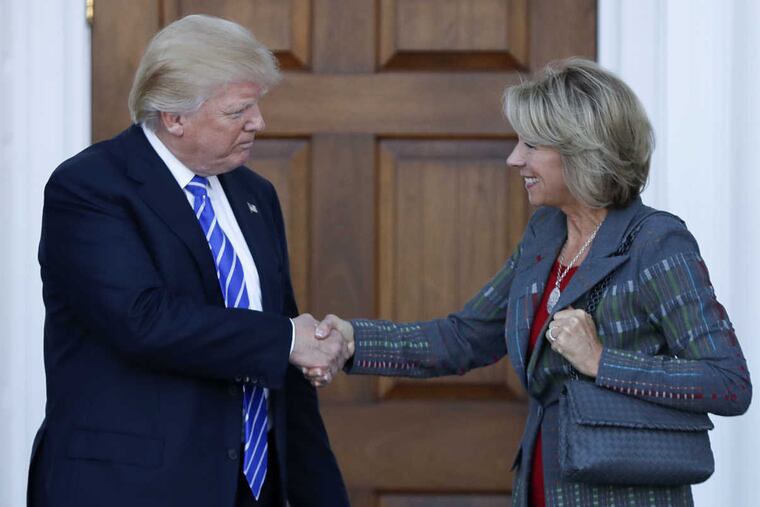 President-elect Donald Trump and Betsy DeVos shake hands at Trump National Golf Club Bedminster clubhouse in Bedminster, N.J., Saturday, Nov. 19, 2016.