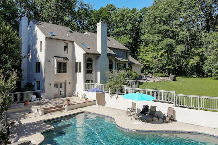 The finished walk-out basement leads to the pool complex, where the two-story pool house includes a five-burner Wolf stove, refrigerator, and full bath.