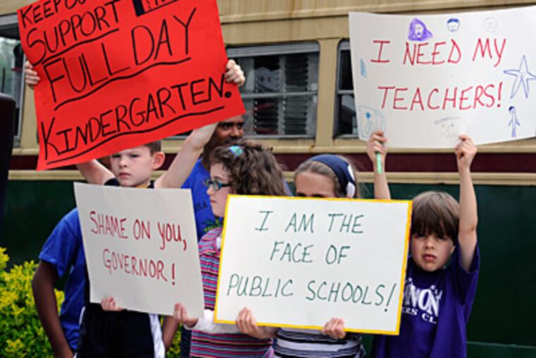 School children hold signs during a May 15 rally at the Trolley Car diner in Mount Airy protesting looming budget cuts that threaten public school services. (Ron Tarver / Staff Photographer)