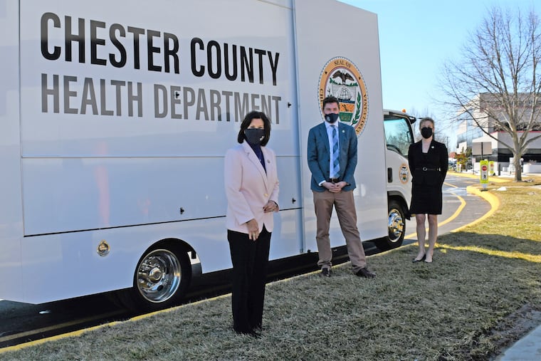 Chester County Commissioners Marian Moskowitz (foreground), Josh Maxwell, and Michelle Kichline, in front of a county Health Department mobile clinic, passed a new ethics policy to promote clean government. But it also includes a confidentiality clause for employees.