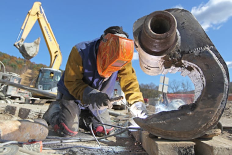 At a natural gas pipeline project in northern Pennsylvania, a welder repairs a piece of broken machinery. (Michael Bryant / Staff Photographer)