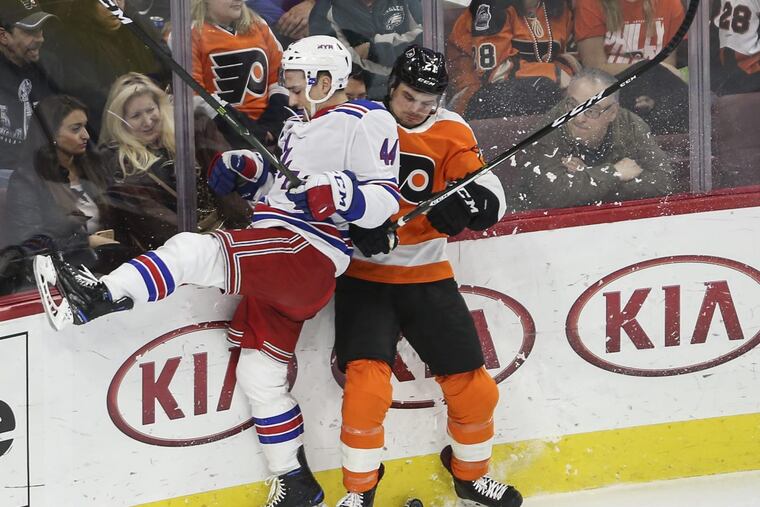 The Flyers’ Scott Laughton checks the Rangers’ Neal Pionk during the first period at the Wells Fargo Center on March 22. The Flyers won, 4-3.