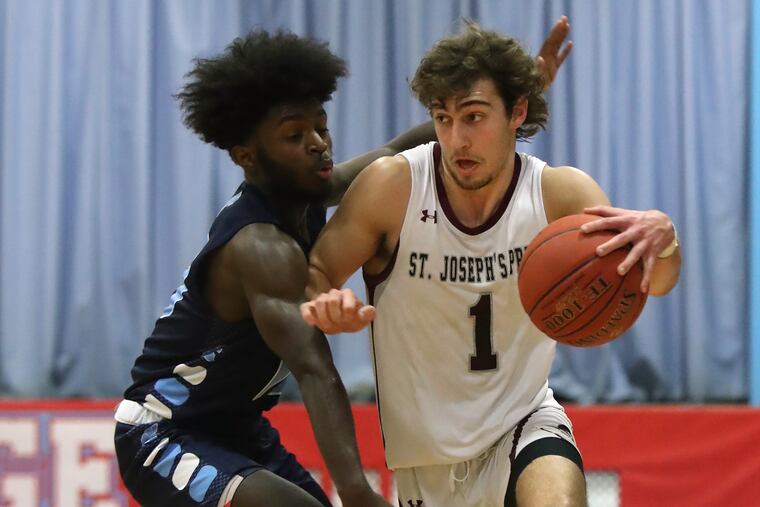 Trevor Wall (right) of St. Joseph's Prep drives against Milton Carter of Olney Charter in a District 12, Class 6A play-in game. Wall has led the Hawks into the PIAA Class 6A state tournament in legendary coach Speedy Morris' last season.