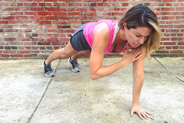 Ashley Greenblatt demonstrates a plank shoulder tap.