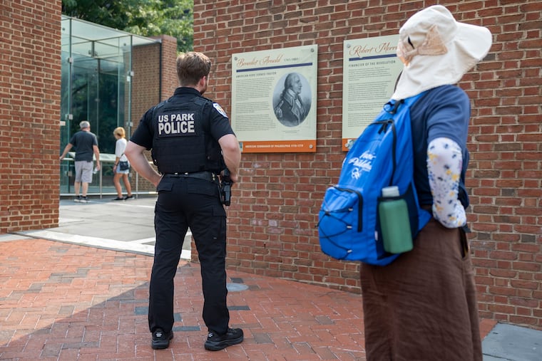 U.S. Park Police Officer Patrick O’Hanlon reads the new panels alongside visitors at the site of the President’s House in Philadelphia on July 16.