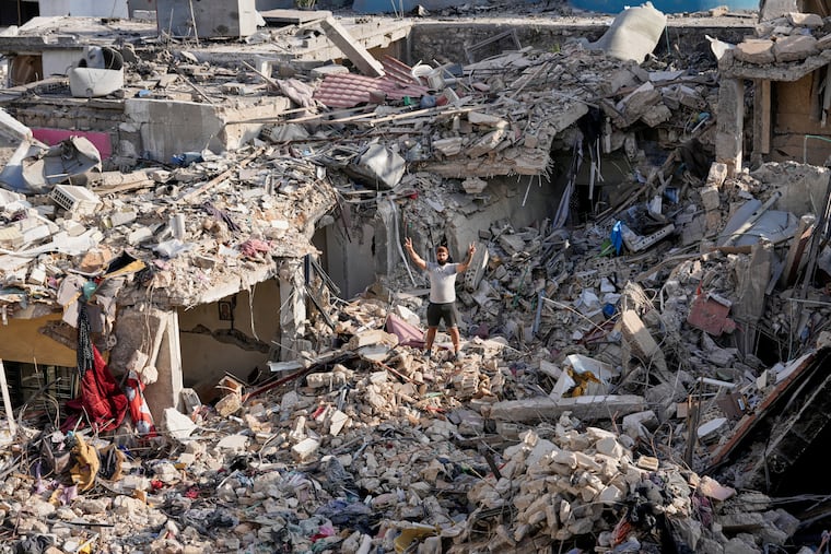 A man who returns to his village following the announcement of an initial ceasefire agreement between the United States and Iran, flashes a victory sign as he stands on the rubble of his destroyed house in Nabatiyeh town, southern Lebanon, Tuesday, June 16, 2026.