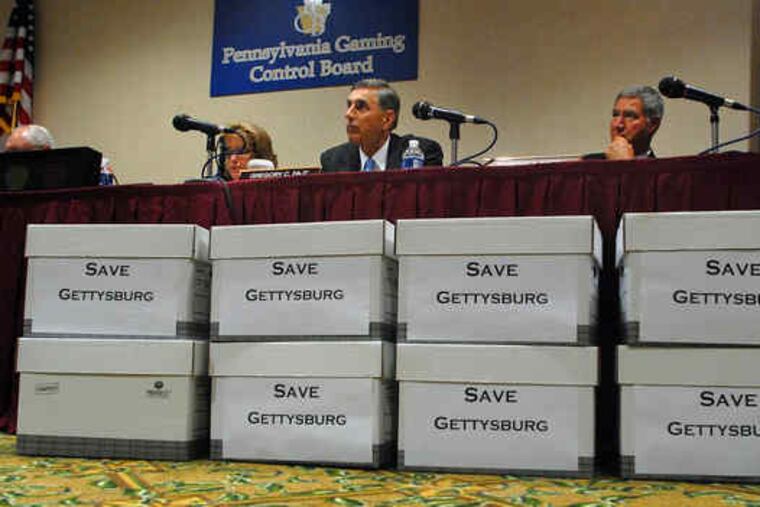 Piles of petitions against the proposed Gettysburg casino line a table as the Gaming Control Board hears testimony.