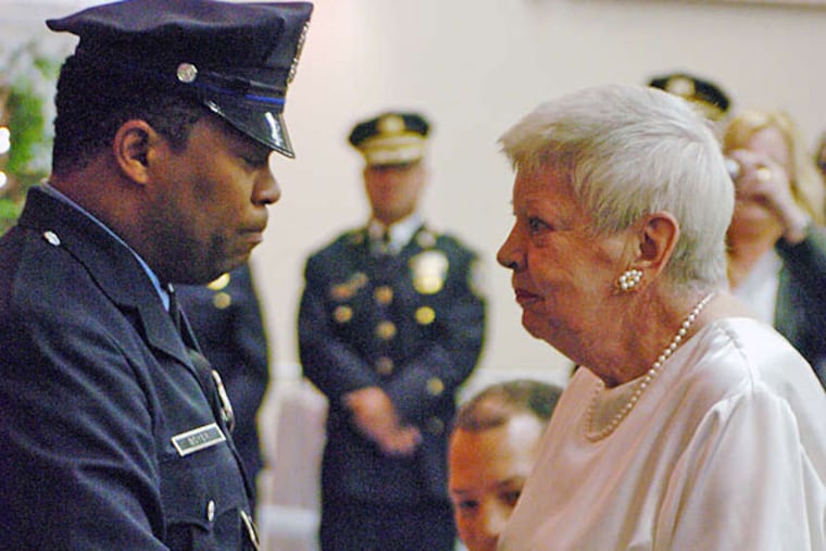 Officer Andre Boyer in 2008 with Rosalyn Harris, sister of Officer Walter Barclay, who was disabled in 1966 and who once wore the same badge number Boyer was later assigned. To honor Barclay, Boyer gave up the number after the officer died in 2007. JESSICA WESTERGOM / File Photograph