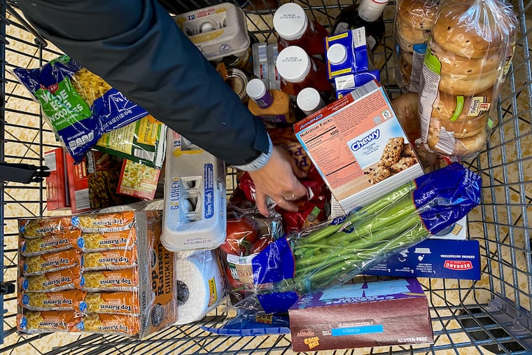 A woman calculates the exact cost of her groceries so she can make sure to stay within her $175-per-month grocery budget while shopping in Binghamton, N.Y.