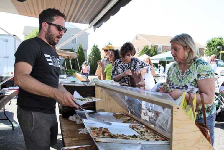 Mike Hauke sells a slice of square pizza to Sharon Ianoale of
Linwood at Tony's Farm Table at the Margate Community Farmers
Market, in the parking lot of Steve & Cookie's, 9700 Amherst Ave.,
Margate City, June 20, 2013.