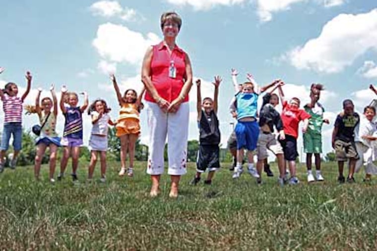 Teacher Shelly Petrozza with her exuberant third graders at the site of the future dog park. (Michael Bryant / Staff photographer)