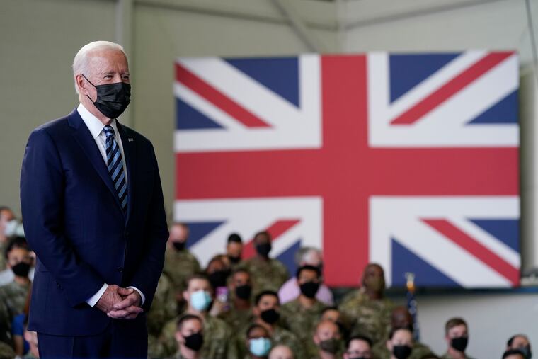 Joe Biden listens as first lady Jill Biden speaks to American service members at RAF Mildenhall in Suffolk, England, during the Bidens' trip abroad.