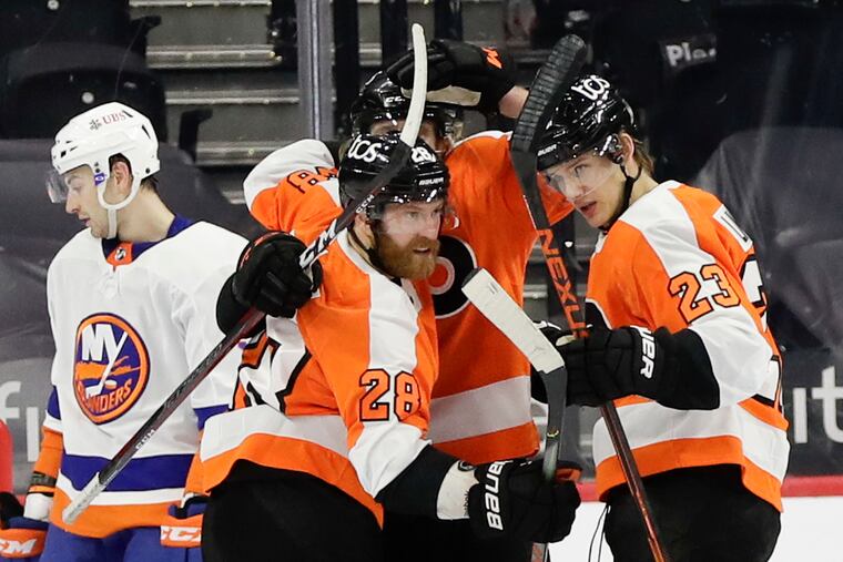 Flyers left winger Oskar Lindblom (right) celebrates his goal with Claude Giroux (28) and Jake Voracek against the New York Islanders last season. Lindblom won the Masterton Trophy Tuesday.