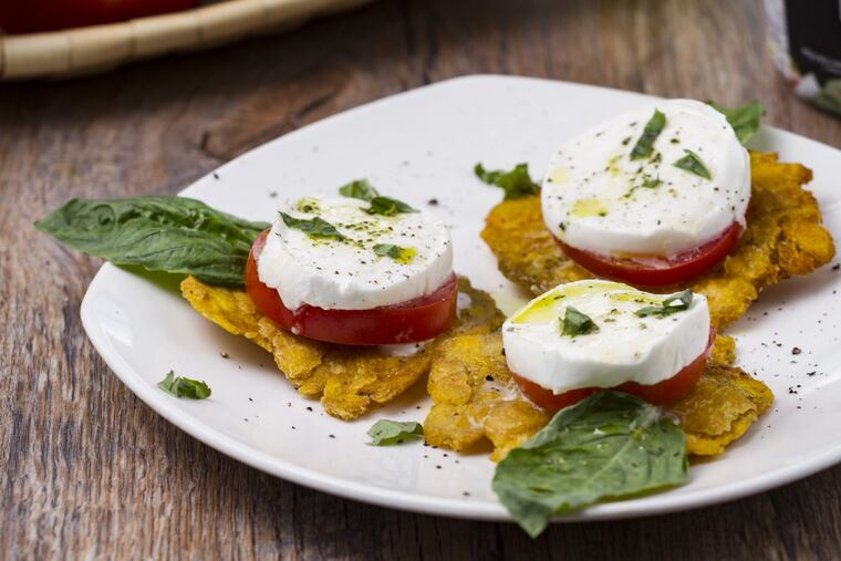 A tropical Caprese "patacone" is made with a slice of Būf buffalo mozzarella, basil and tomato layered atop a crispy fried plantain.