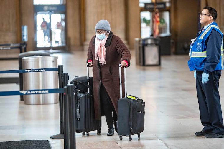 An Amtrak passenger wears a mask at 30th Street Station in March. The agency is now requiring riders to wear masks.