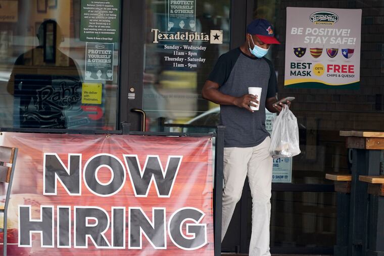 A customer walks past a hiring sign at an eatery in Richardson, Texas.