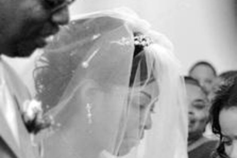 Shammara Winbush walks down the aisle accompanied by her father, Anthony Winbush. She's wearing a Cinderella-style ballgown with beaded white gloves, tiara, and a bouquet of calla lilies.