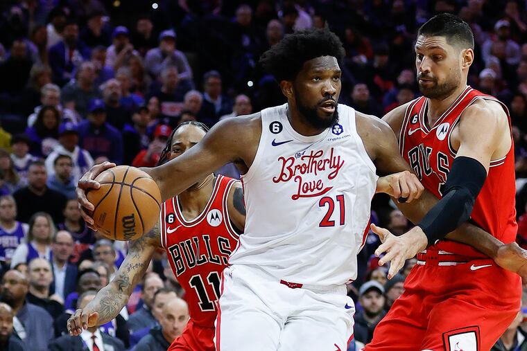 Sixers center Joel Embiid drives to the basket against Chicago Bulls center Nikola Vucevic and forward DeMar DeRozan on Monday, March 20, 2023 in Philadelphia.