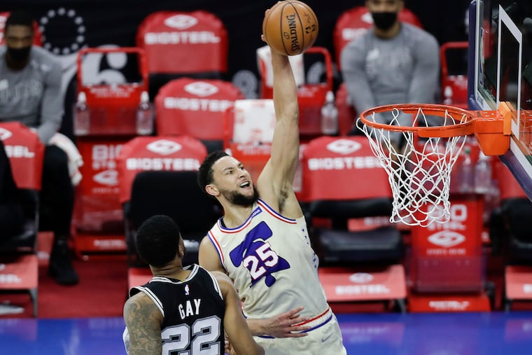 Sixers guard Ben Simmons rises to dunk over San Antonio Spurs forward Rudy Gay in the second quarter on Sunday.