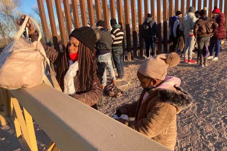 FILE - A Cuban woman and her daughter wait in line to be escorted to a Border Patrol van for processing in Yuma, Ariz., Sunday, Feb. 6, 2022, hoping to remain in the United States to seek asylum. U.S. authorities have lifted a public health order to expel unaccompanied children at borders without a chance at asylum, while leaving it in place for adults and people traveling in families.