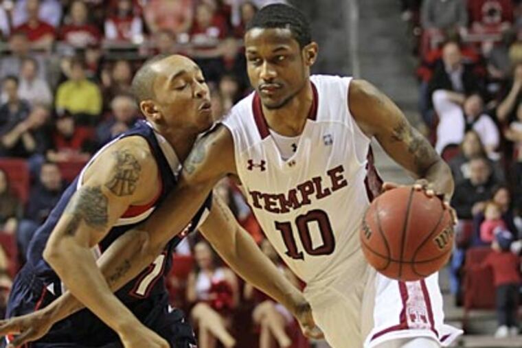 Duquesne's Mike Tally guard's Temple's Ramone Moore in the first half on Saturday. (Michael Bryant/Staff Photographer)